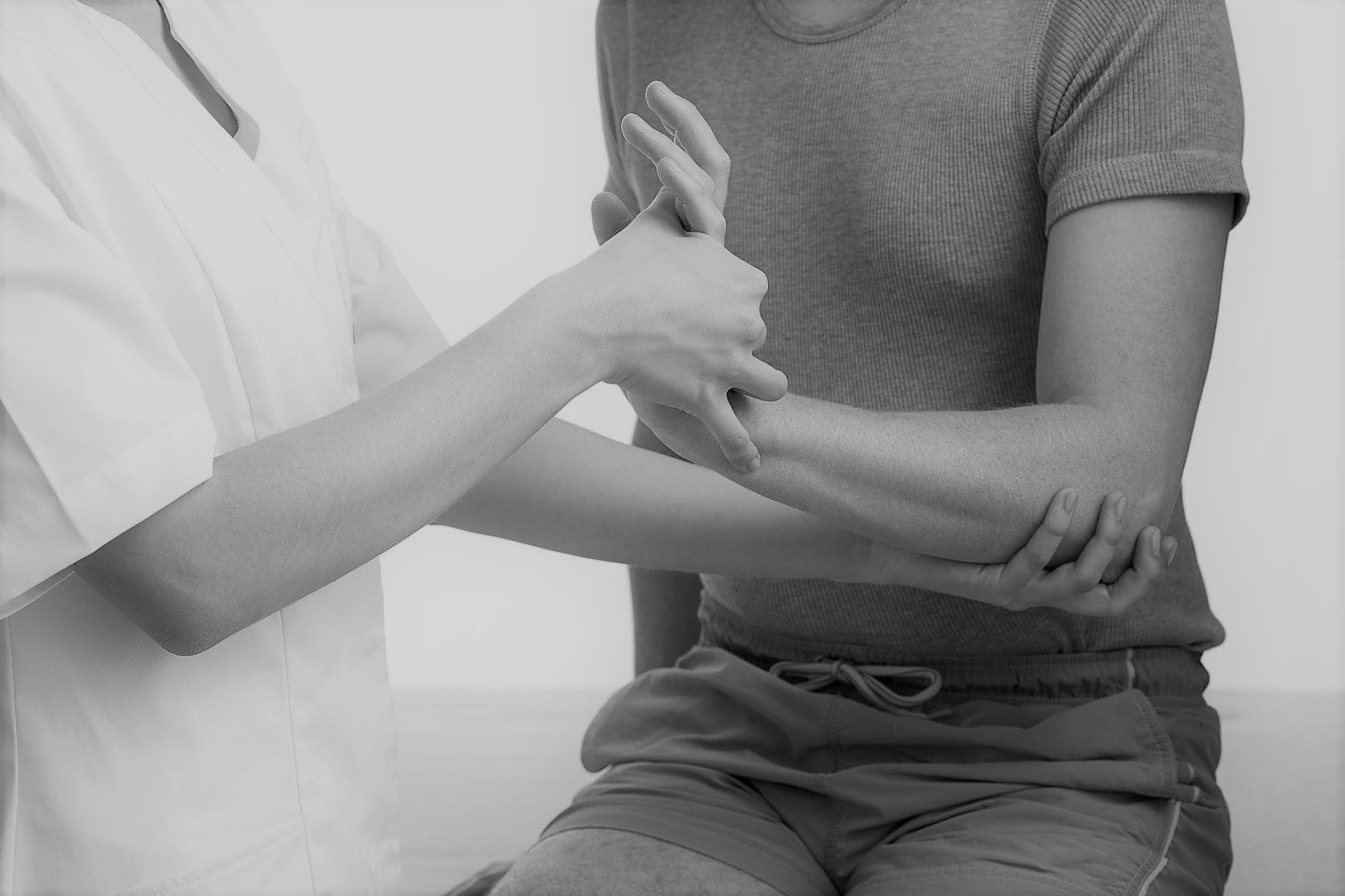 doctor helping patient stretch injured wrist